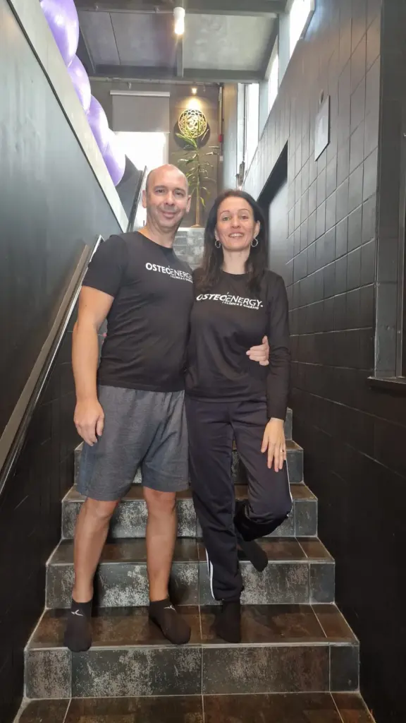 Duas pessoas da equipa Osteoenergy, nas escadas da clínica