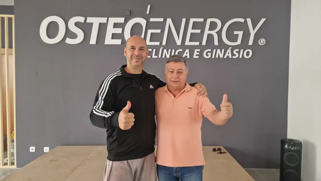 Duas pessoas da equipa Osteoenergy, em frente ao letreiro do ginásio