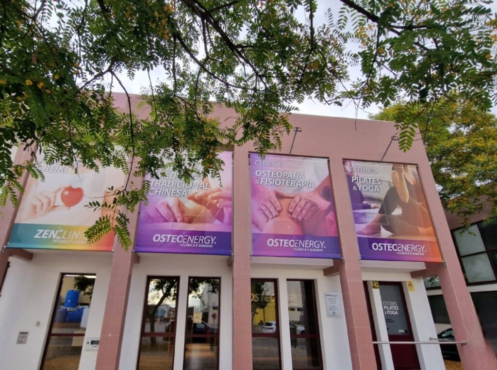 Fachada da Clínica Osteoenergy na Rua Circular Poente, Évora, com as lonas das especialidades