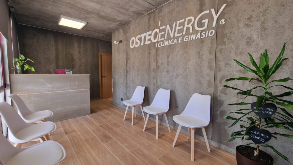 Receção da Clínica Osteoenergy, com o logótipo em relevo na parede de betão